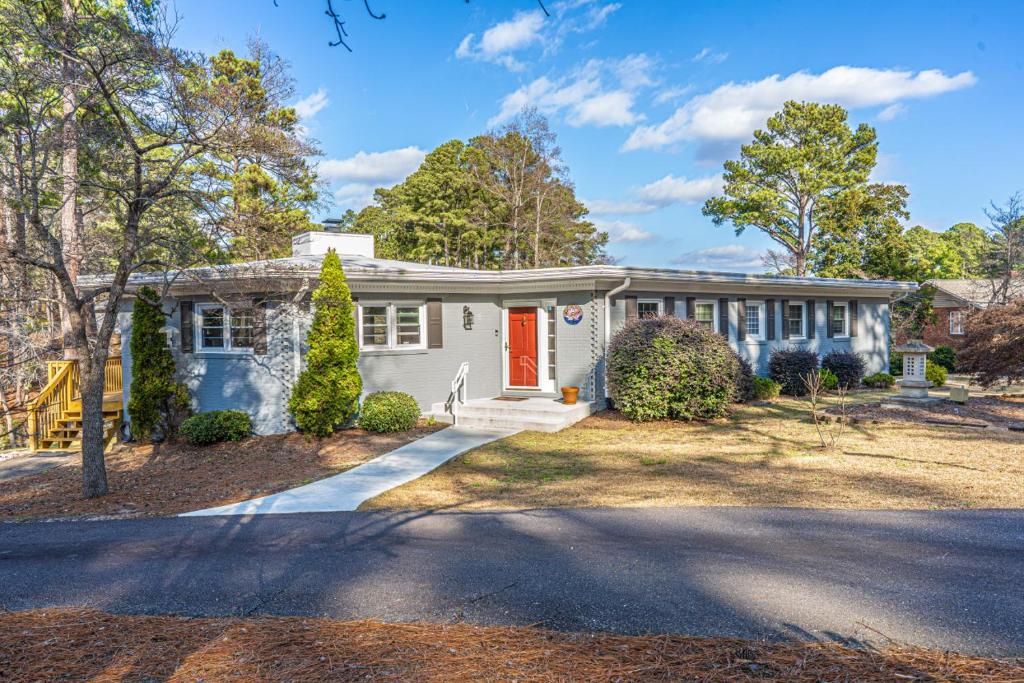 a white house with a red door on a street at Sleeps 6- Whispering Pines Lakefront 