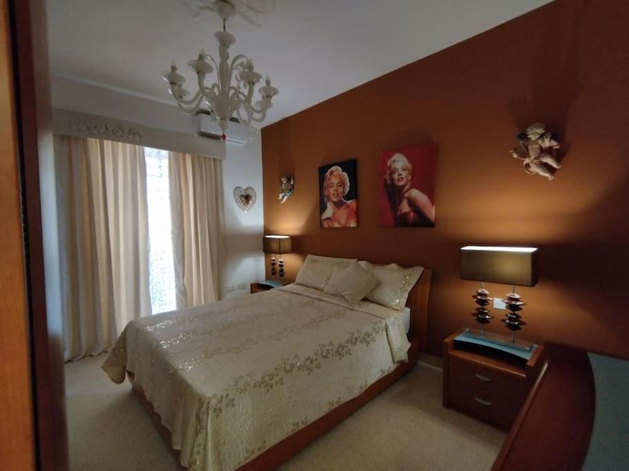 a bedroom with a bed and two pictures on the wall at Tal-Munfuha- Centrally Located Space. in Valletta