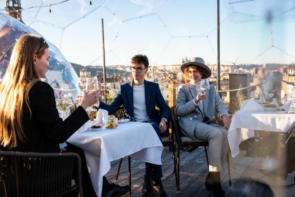 a group of people sitting at a table with wine glasses at Pytloun Boutique Hotel Prague in Prague