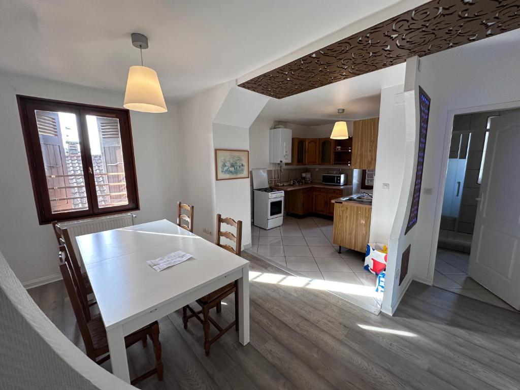 une cuisine et une salle à manger avec une table et des chaises dans l'établissement Logements Gare Brignoud, à Villard-Bonnot