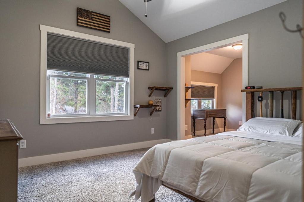 a bedroom with a large bed and a window at Sleeps 8-Whispering Pines 