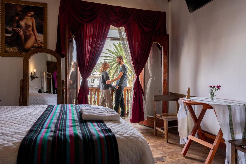 two women standing in a bedroom looking out the window at Casona Del Rosario - Plaza de Armas in Chachapoyas