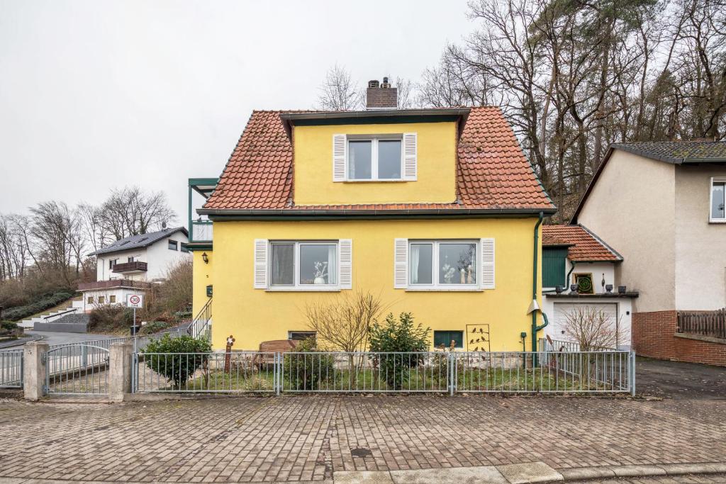 a yellow house with a fence in front of it at Villa Reinhilde in Felsberg
