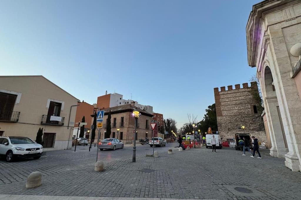 eine Kopfsteinpflasterstraße in einer Stadt mit geparkten Autos in der Unterkunft Estudio Herrero in Alcalá de Henares