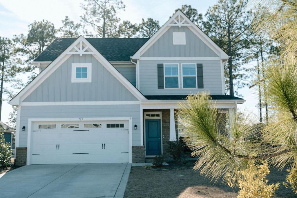 une maison grise avec un garage blanc dans l'établissement Sleeps 9- In Whispering Pines, à Carthage