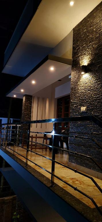 a person is standing on a balcony at night at Ceebeez homes in Ernakulam