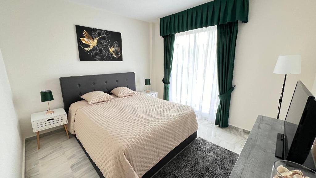 sypialnia z łóżkiem i dużym oknem w obiekcie Costalita - 2 bedroom apartment 350m from the beach w mieście Estepona