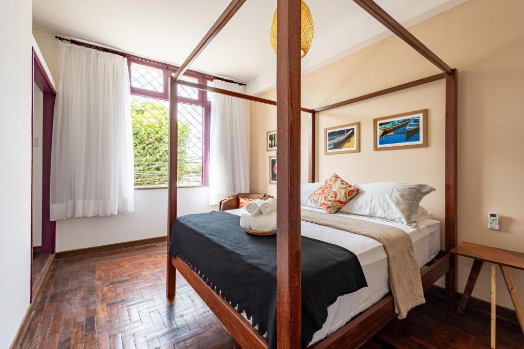 a bedroom with a four poster bed and a window at Hotel Casa do Bispo in Manaus