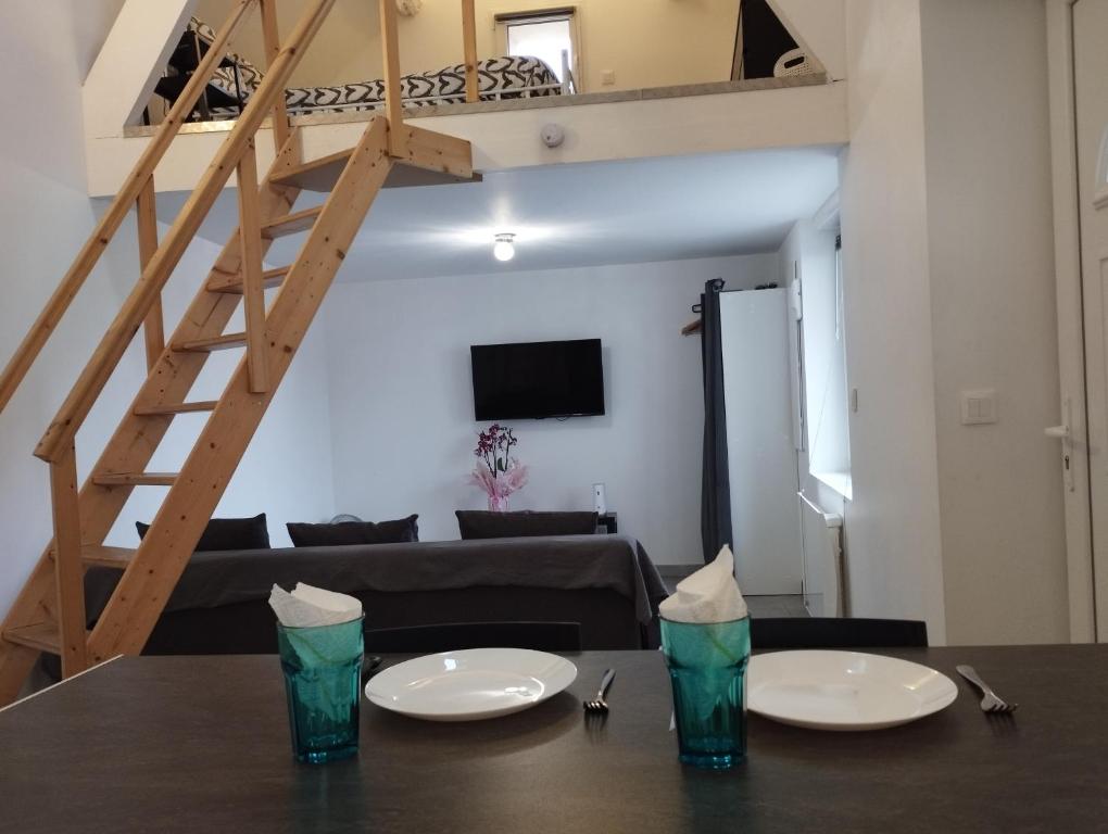 uma sala de estar com uma mesa com dois pratos em Appartement 1, jardin, collation, 5 min de l'aéroport CDG em Le Mesnil-Amelot
