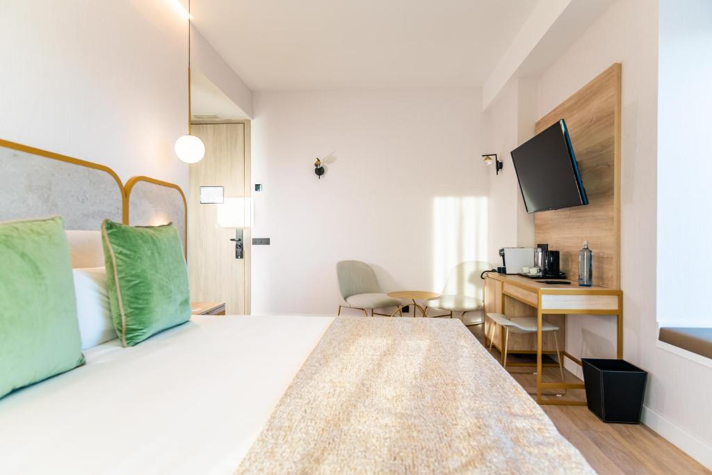 a bedroom with a bed and a desk with a computer at Hotel Málaga Vibes in Málaga