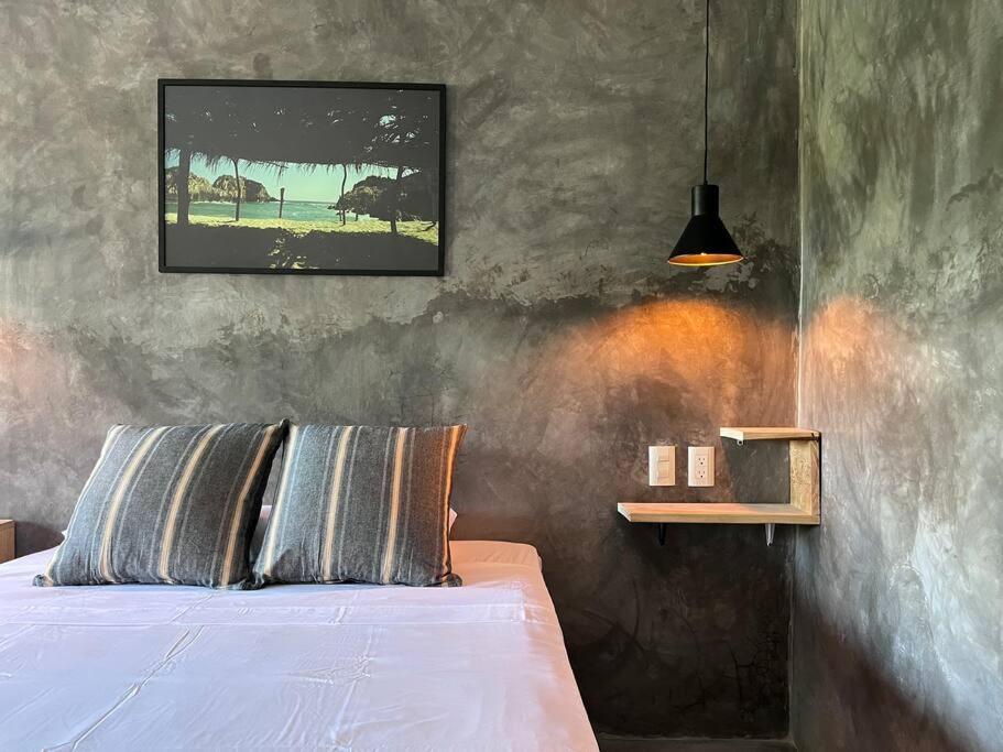 um quarto com uma cama e uma fotografia na parede em Depto Sayula HoMe con alberca 6 em Sayulita