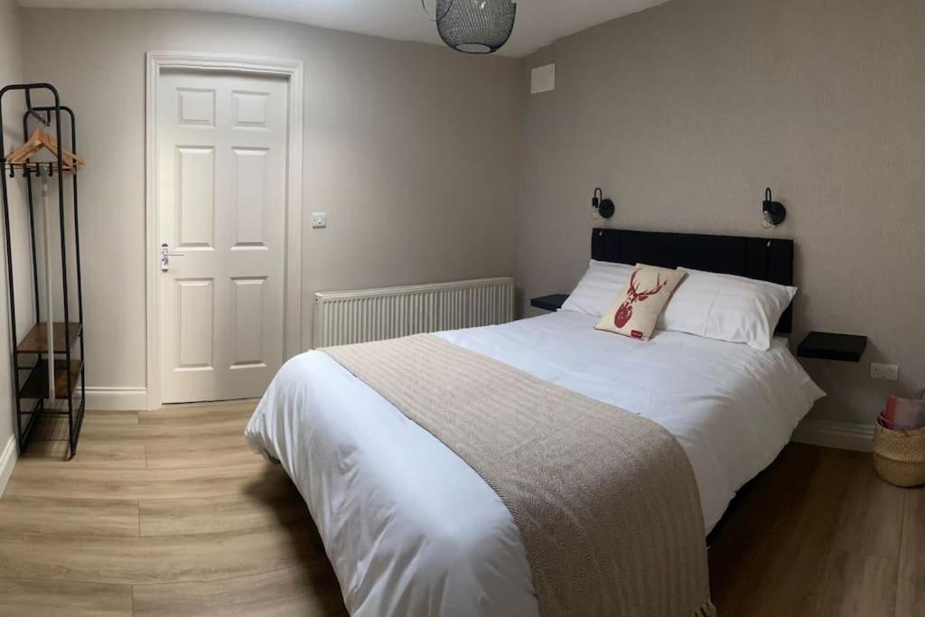 una camera da letto con un grande letto bianco con due cuscini di Castletroy Apartment a Limerick