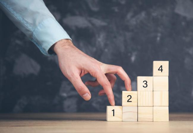 une main empilant des blocs de bois avec des chiffres dessus dans l'établissement Apartamento de prueba, à Saint-Domingue