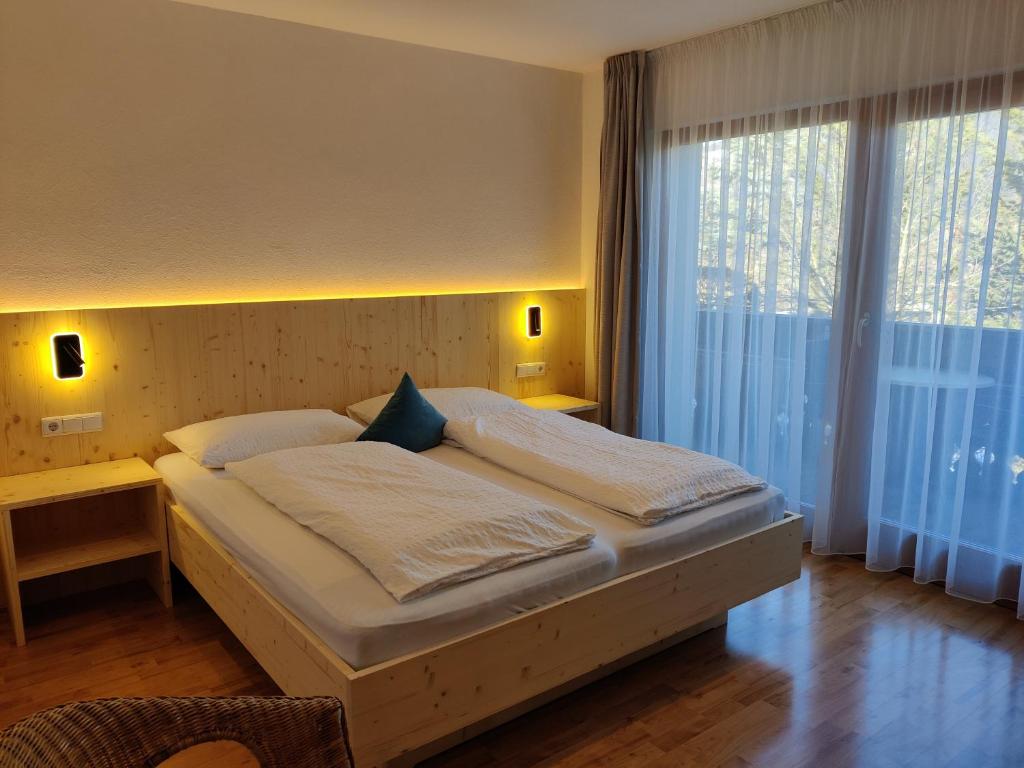 sypialnia z łóżkiem i dużym oknem w obiekcie Residence Klementhof 1 w mieście Fiumes