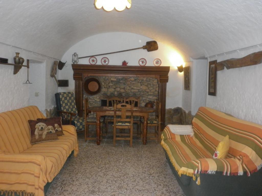 a living room with two couches and a fireplace at Alojamiento Rural LA TEJA in Cortes de Baza