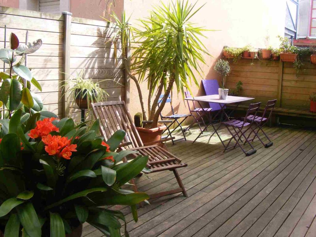 une terrasse avec une table, des chaises et des plantes dans l'établissement Hulotte, à Soorts-Hossegor