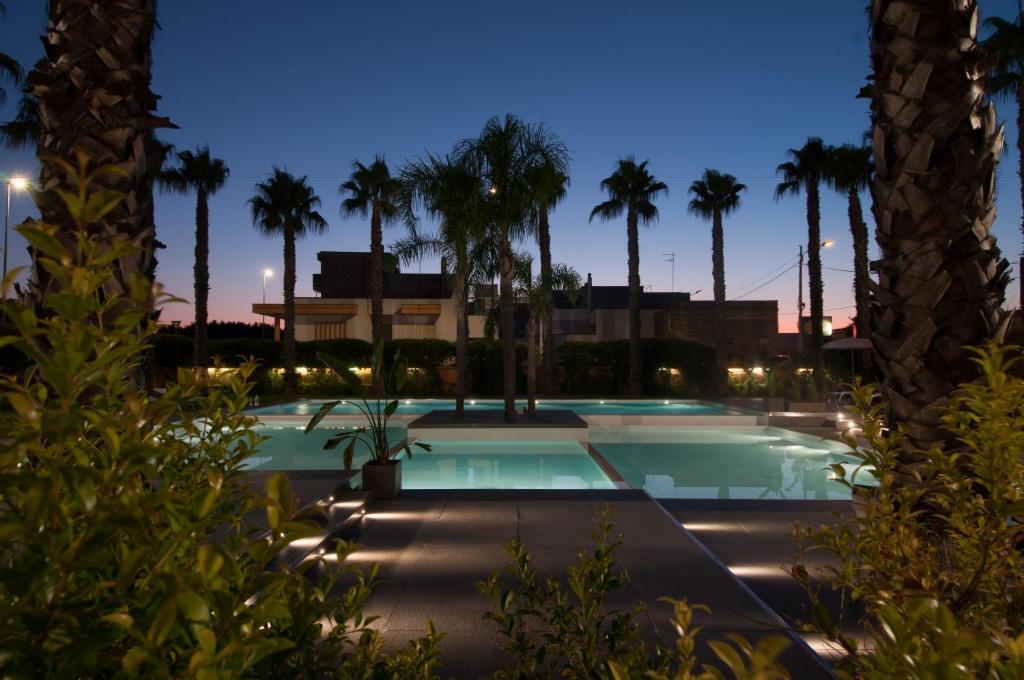 a swimming pool at night with palm trees at Sanlu Hotel in Serrano