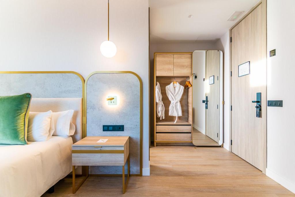a bedroom with a bed and a dressing room at Hotel Málaga Vibes in Málaga