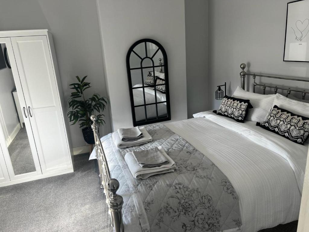 a bedroom with a large bed and a mirror at Quay Cottage in Parkgate