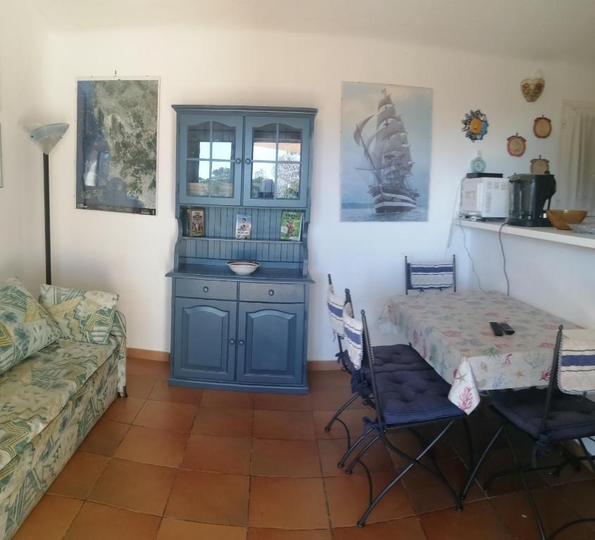 soggiorno con tavolo e mobile blu di Casale di Mare Palombaggia a Porto Vecchio