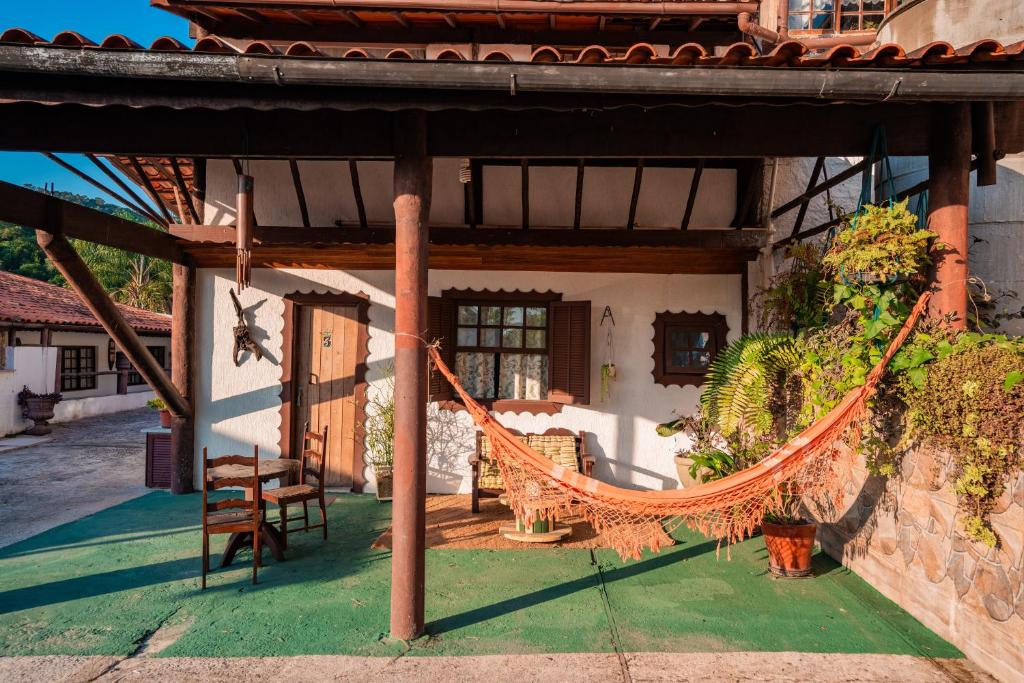 a house with a hammock in the front yard at Alameda Galu in Atibaia