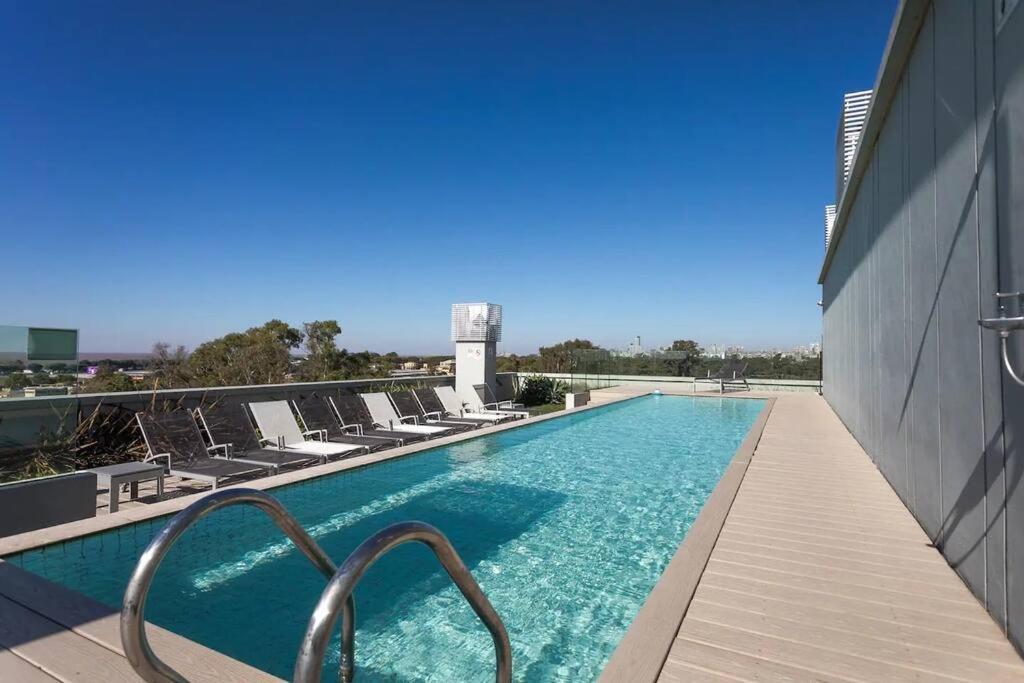 una piscina con tumbonas en un edificio en Apart de categoría con amenities y estacionamiento en Buenos Aires