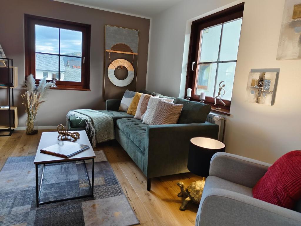 ein Wohnzimmer mit einem grünen Sofa und einem Tisch in der Unterkunft Apartment Artista in Weitensfeld