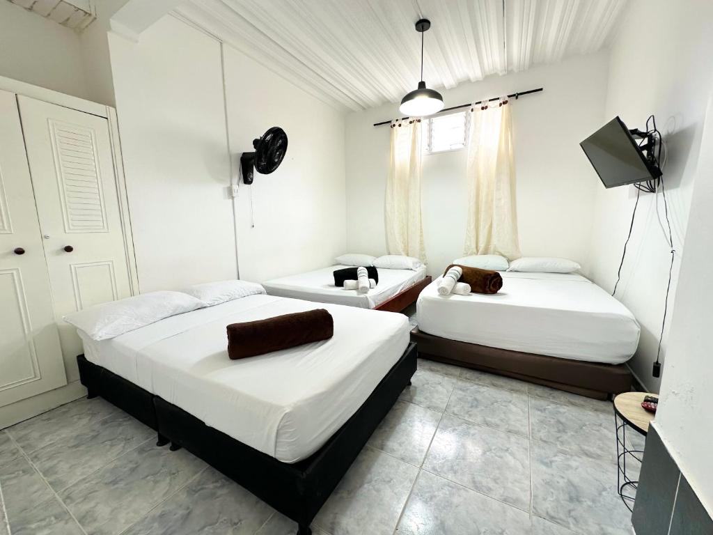 a room with two beds and a television in it at Acogedor Apartamento En La Circunvalar By Parceros Group in Pereira