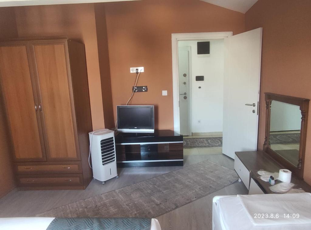 a hotel room with a television and a bedroom at GÜL APART SUİT in Istanbul