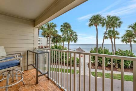 a balcony with a view of the ocean and palm trees at Oceans Pointe Nantucket inspired condo on the bay in Tampa