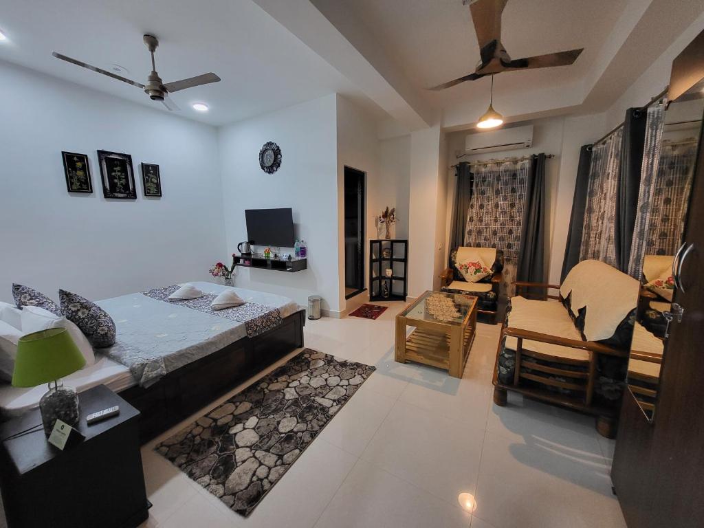 a bedroom with a bed and a living room at Hebron Haven in Jaigaon