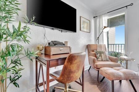 タンパにあるThe Hemingway subtropical luxury on the Tampa Bayのリビングルーム(デスク、椅子、テレビ付)