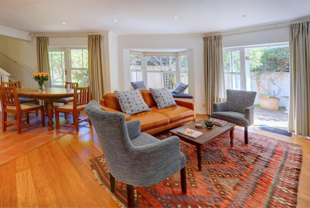 a living room with a couch and chairs and a table at Sunbird Cottage - Wilderness in Wilderness