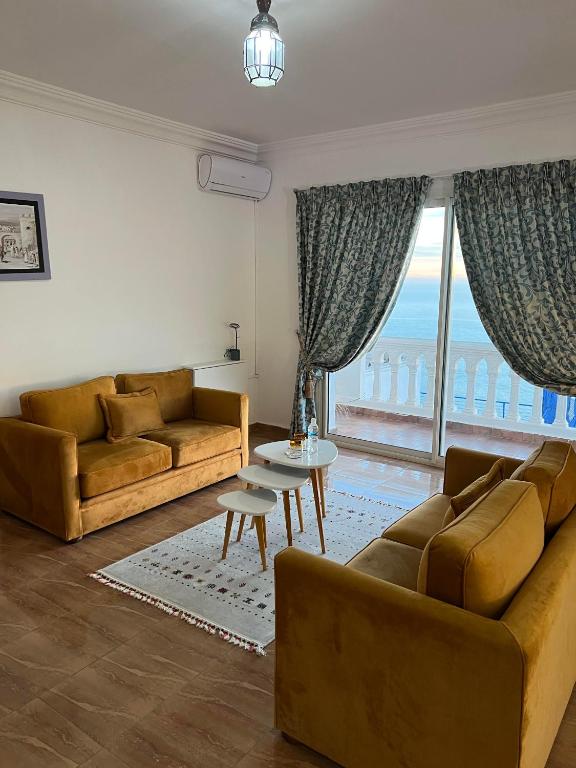 a living room with two couches and a table at Riad Ras Lafaa in Safi