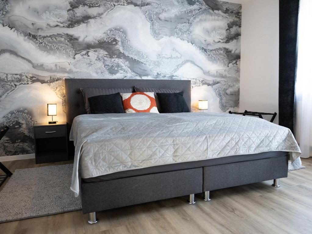 a bedroom with a large bed with a wall mural at City - Apartment Weststadt in Karlsruhe