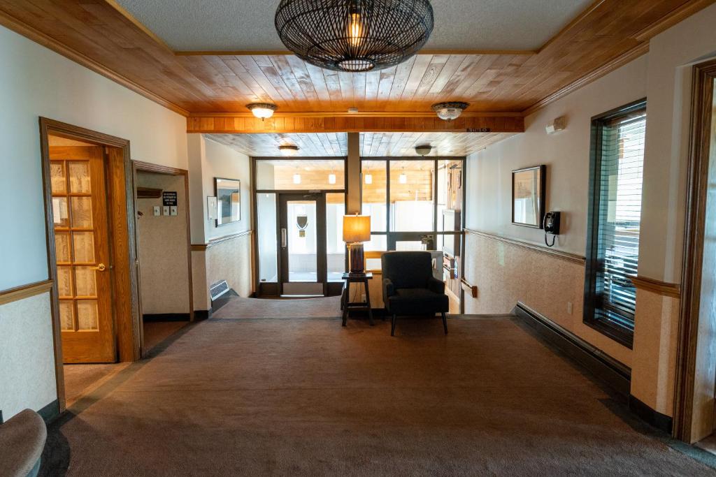 an empty hallway with a chair and a lamp at Auberge le Parasol in Saguenay