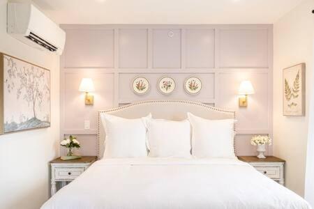 1 dormitorio con 1 cama blanca grande con almohadas blancas en Downtown Luxury Farmhouse Apartment #3, en West Dundee