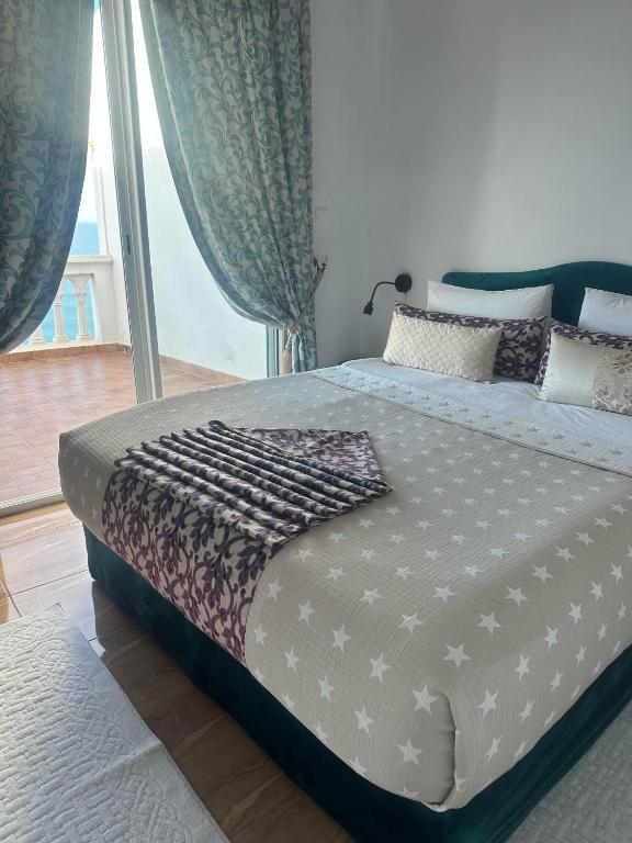 a large bed in a bedroom with a large window at Riad Ras Lafaa in Safi