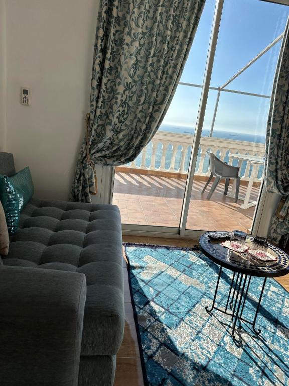 a living room with a couch and a view of the ocean at Riad Ras Lafaa in Safi