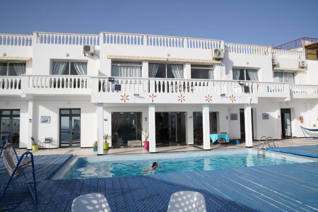a person swimming in a swimming pool in front of a building at Riad Ras Lafaa in Safi