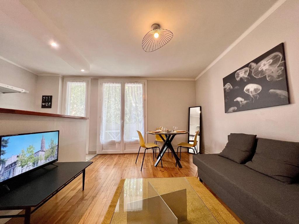 un salon avec un canapé et une table dans l'établissement Paisible T3 proche métro, WI-FI & terrasse privée, à Toulouse