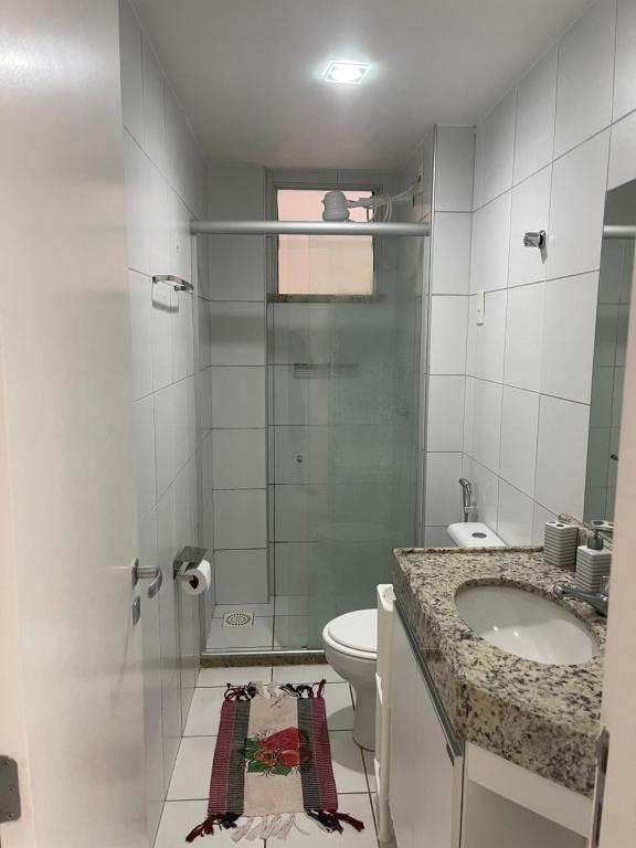 y baño con ducha, aseo y lavamanos. en Exelente Apartamento Porto das Dunas, en Aquiraz