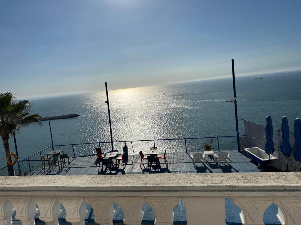 a balcony with tables and chairs and the ocean at Riad Ras Lafaa in Safi