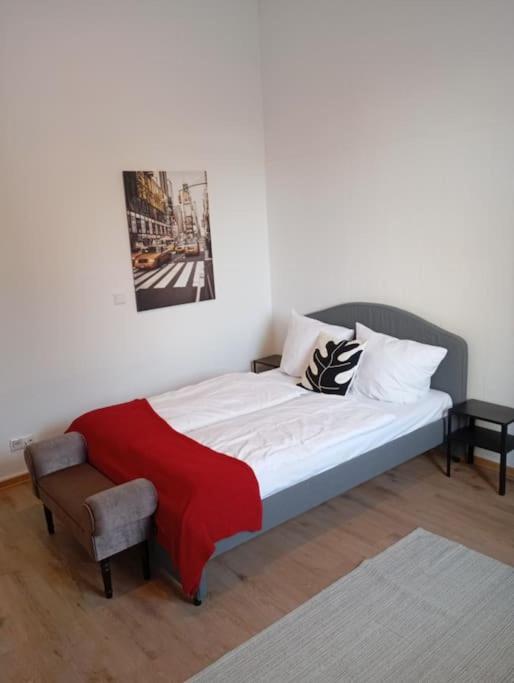 uma cama com um cobertor vermelho e uma cadeira num quarto em Apartment Koblenz nähe Uni und BWZK em Koblenz