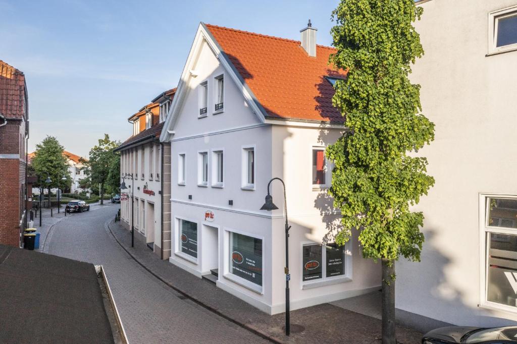a white building with an orange roof on a street at Zum Brandenburger Tor in Damme