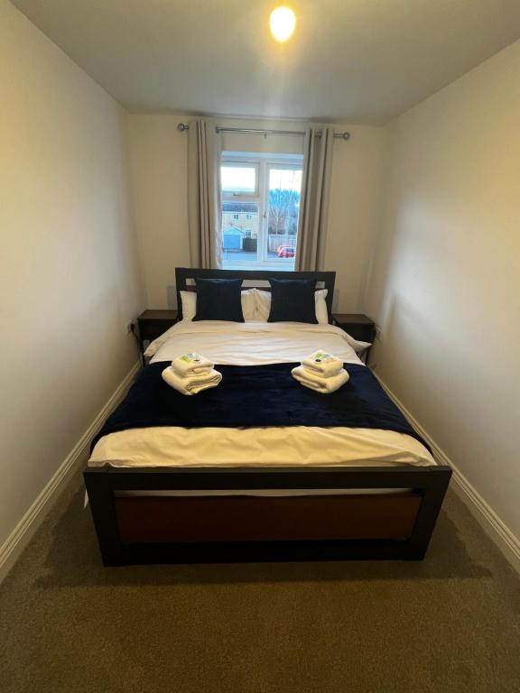 a bedroom with a bed with two towels on it at Newly built one bedroom flat in Kidlington, Oxfordshire in Kidlington