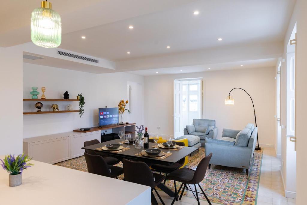 een eetkamer en een woonkamer met een tafel en stoelen bij Florette Suite Designer Finish in Floriana in Il-Furjana