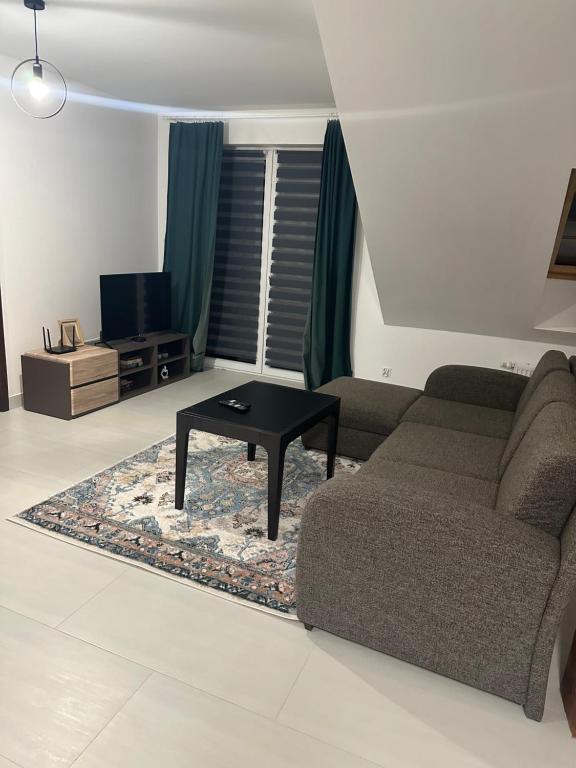 a living room with a couch and a coffee table at Apartament Oksford 3 in Okszów