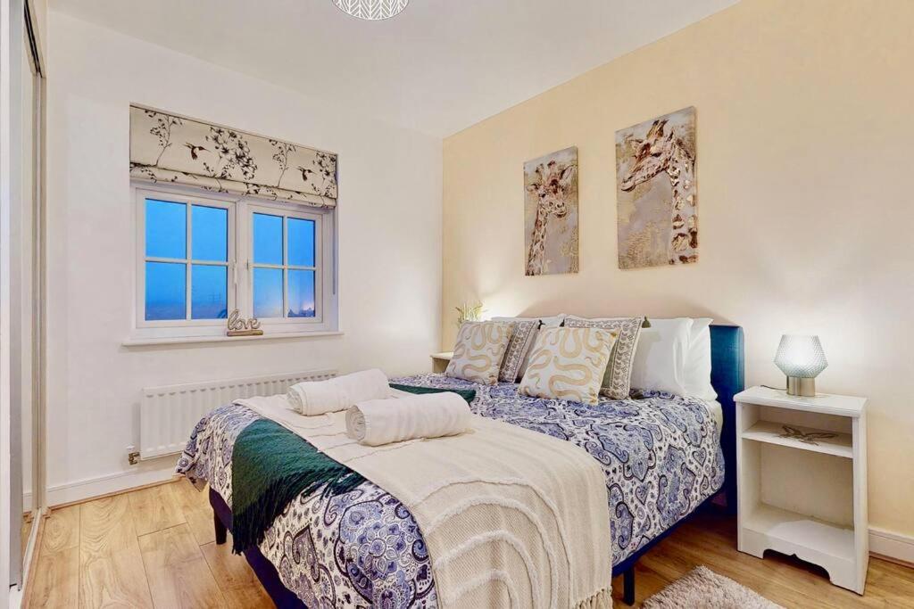 a bedroom with two beds and two windows at Candy Dene, Top Floor Apartment in Swanscombe