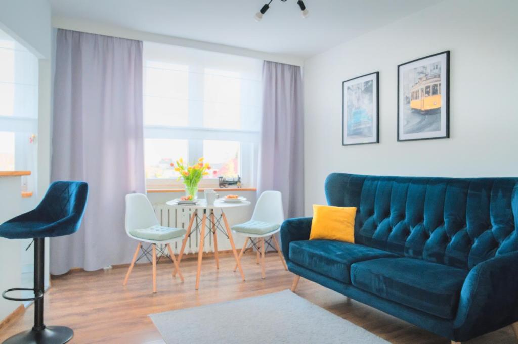 Mieszkanie do wynajęcia w centrum Kraśnika في كراسنيك: غرفة معيشة مع أريكة زرقاء وطاولة